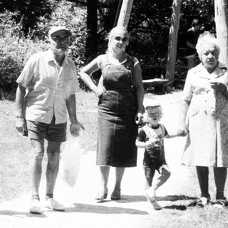 Family walking outdoors near a water tower.