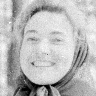 A cheerful person smiling in winter forest snow.