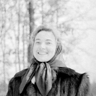 A cheerful person smiling in winter forest snow.