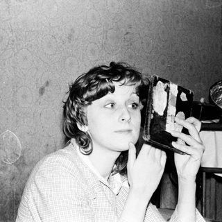 Woman using vintage portable radio.