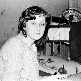 Young woman sitting at sewing table with fabric.