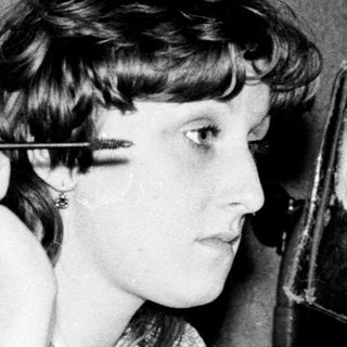 Person using vintage hair straightener indoors.