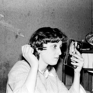Person using vintage hair straightener indoors.