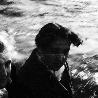 Two men on boat in rough sea.