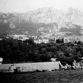 Historic coastal town with mountainous backdrop.