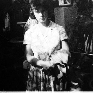 Vintage photo of woman in 1920s-style dress with feathered decor.