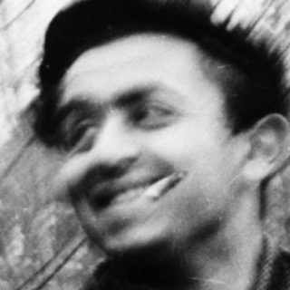 Two men smiling outdoors in vintage-style photograph.