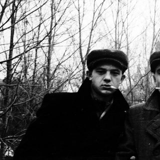 Two men in vintage winter attire posing outdoors.