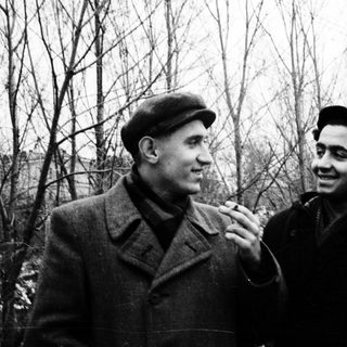 Two men in winter attire smiling outdoors.