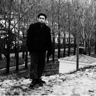A man in winter attire standing outdoors in snow.