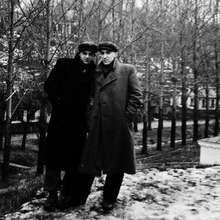 Two men posing outdoors in winter attire.
