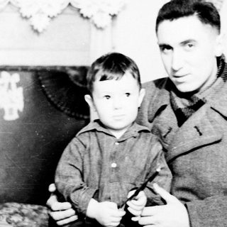 A man and young boy posing indoors together.