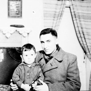 A man and young boy posing indoors together.