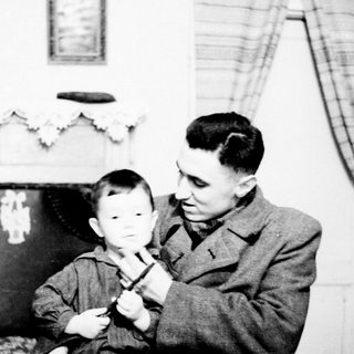 A man teaching a young boy to play piano.