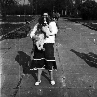 Family with dog and child in outdoor setting.