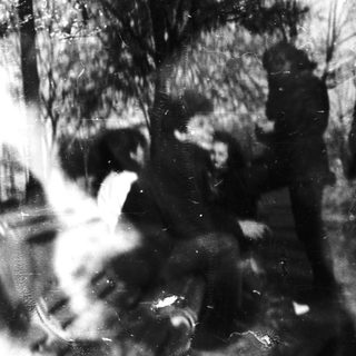 Blurry black-and-white street scene with dog and person.