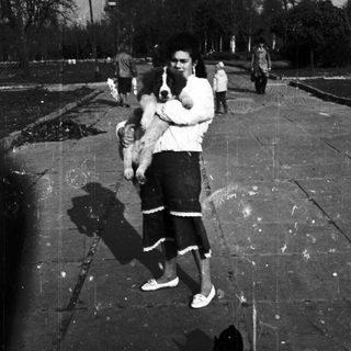 A man holding a child in an outdoor pool area.