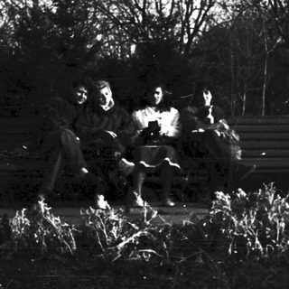 People sitting around an outdoor campfire.