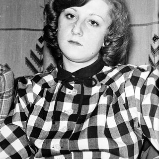 Young woman in checkered shirt, mid-20th century style.