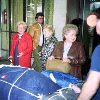 People carrying a draped stretcher indoors.