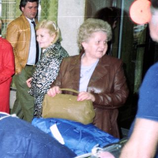 People carrying a draped stretcher indoors.