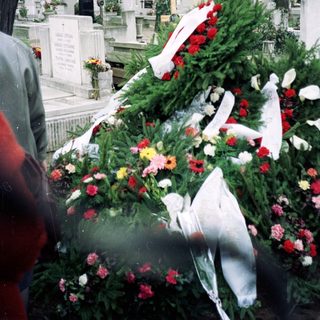Memorial grave adorned with flowers and wreaths.