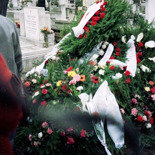 Memorial grave adorned with flowers and wreaths.