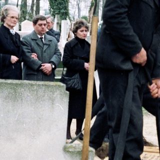 People tending graves in a cemetery.