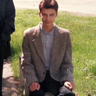 Two men posing by a riverbank in springtime.