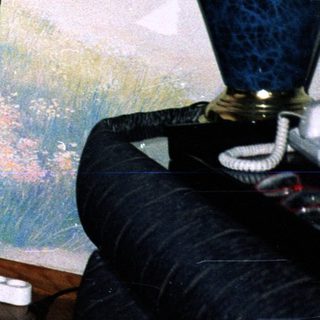 Man in formal attire sitting in armchair indoors.