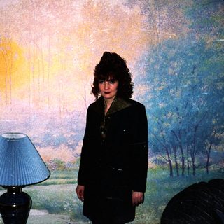 Woman standing in front of large landscape mural.