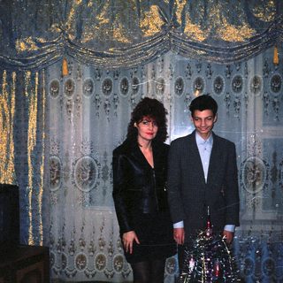 Two people dressed formally in an ornate indoor setting.
