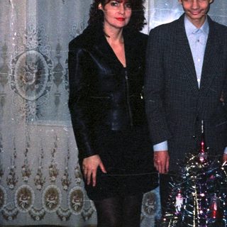 Two people dressed formally in an ornate indoor setting.