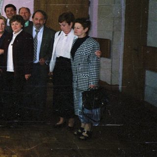 Group of people posing indoors near mural.