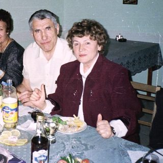 Family gathering enjoying meal and drinks indoors.