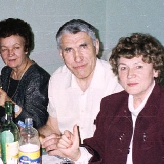 Family gathering enjoying meal and drinks indoors.