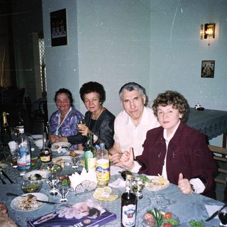 Family gathering enjoying meal and drinks indoors.