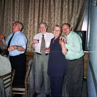 Group of adults toasting indoors at a celebratory dinner.