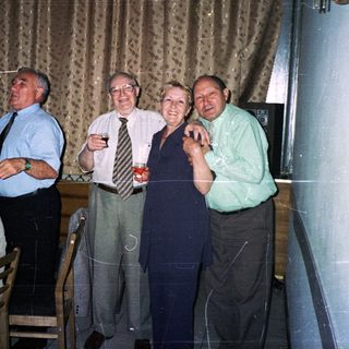 Group of adults toasting indoors at a celebratory dinner.