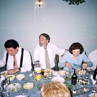 Four adults dining together at a festive table.