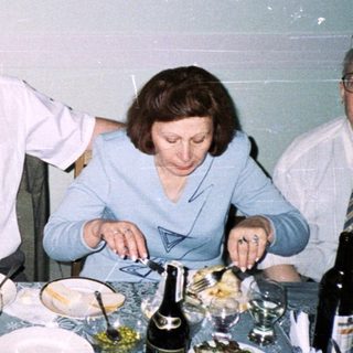 Four adults dining together at a festive table.