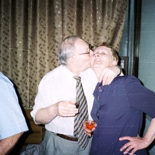 Two people sharing a playful kiss indoors.