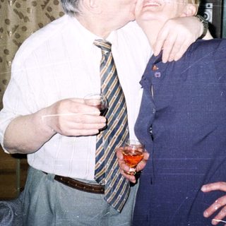 Two people sharing a playful kiss indoors.