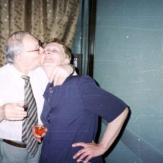 Two people sharing a playful kiss indoors.