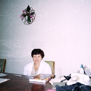 Office setting with woman seated at desk.