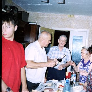 Family gathering indoors with drinks and food.