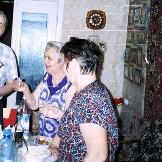 Family gathering indoors with drinks and food.