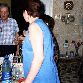 Family gathering with drinks and conversation in a home kitchen.