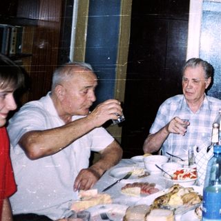 Family gathering enjoying meal and drinks indoors.