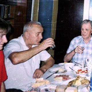 Family gathering enjoying meal and drinks indoors.